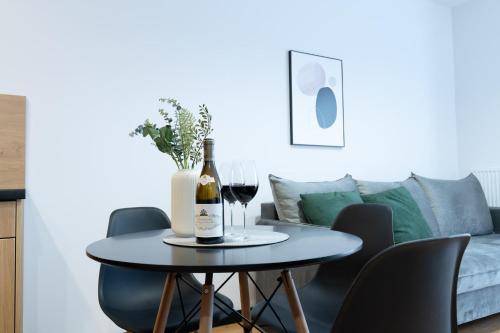 a table with a bottle of wine and two glasses at Slow River Apartment in Nowe Miasto Lubawskie