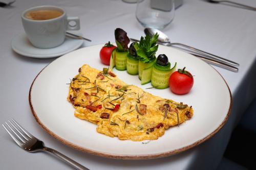 Un plato de tortilla con verduras y una taza de café en MPM Hotel Sport Ski-in, Ski-out, en Bansko
