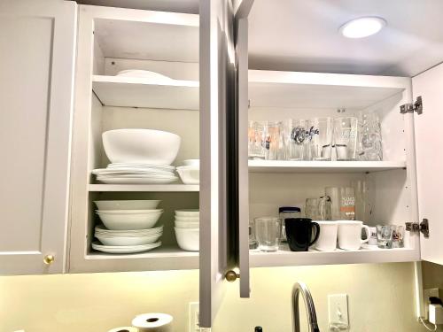- une armoire de cuisine avec des assiettes et de la vaisselle dans l'établissement Glover Park/Georgetown Oasis with parking, à Washington
