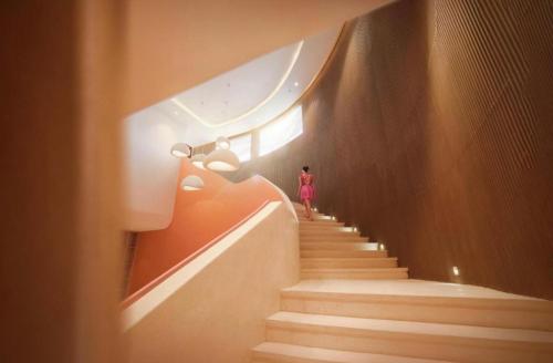 a person walking down the stairs in a building at Apec MANDALA CHAM BAY MUI NE SPA RESORT AND CONDOTEL in Ấp Thiẹn Ái
