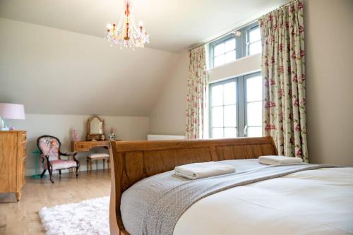 a bedroom with a bed with two towels on it at Luxury Lodge-Lough Erne Resort in Ballycassidy
