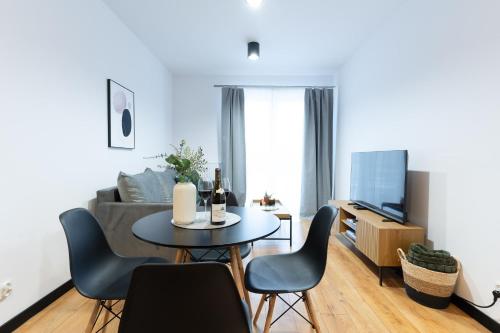 sala de estar con mesa, sillas y sofá en River Song Apartment, en Nowe Miasto Lubawskie