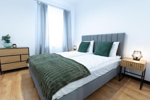 1 dormitorio con 1 cama grande con manta verde en River Song Apartment, en Nowe Miasto Lubawskie