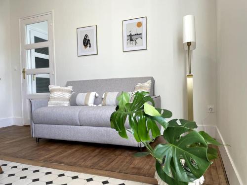 un salon avec un canapé et une plante dans l'établissement Appartement entièrement rénové proche gare, à Grenoble