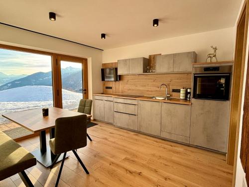 a kitchen with a table and a dining room at Schneiderhof, Urlaub auf dem Bauernhof in Ridanna