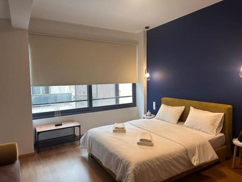 een slaapkamer met een groot bed en een groot raam bij Luxury Suites Athens 2 in Athene