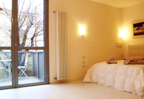 a bedroom with a bed and a large window at Appartamento Levante in Bologna