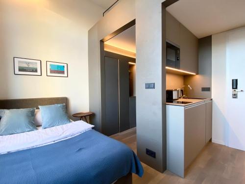 a bedroom with a bed and a small kitchen at OBERDECK Studio Apartments - Adults only in Hamburg