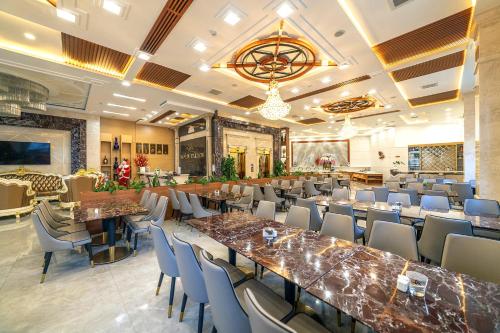 um restaurante com mesas e cadeiras num quarto em Royal Palace em Da Lat
