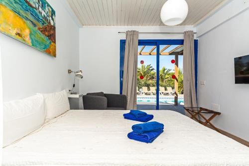 una camera da letto con un letto con asciugamani blu di Villa Cangrejita Private Pool Playa Blanca By PVL a Playa Blanca