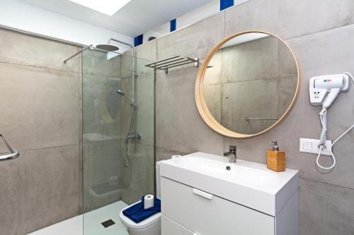 a bathroom with a shower and a sink and a mirror at Villa Cangrejita Private Pool Playa Blanca By PVL in Playa Blanca