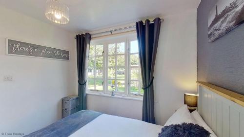 a bedroom with a bed and a window at 12 Tudor Court, Tolroy Manor in Hayle