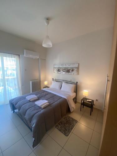 a bedroom with a large bed with two towels on it at Athina’s apartment in Athens