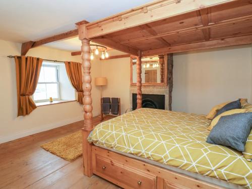 a bedroom with a wooden bed in a room at Swinhope View in Hexham
