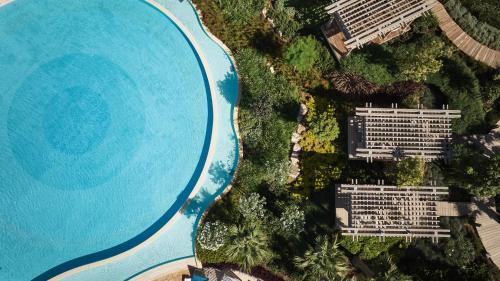 an overhead view of a swimming pool next to a lake at City of Dreams Mediterranean - Integrated Resort, Casino & Entertainment in Limassol