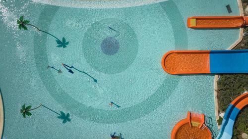 a group of people swimming in a swimming pool at City of Dreams Mediterranean - Integrated Resort, Casino & Entertainment in Limassol