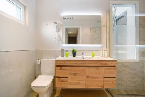 uma casa de banho com um WC, um lavatório e um espelho. em Villa Laian Branded Residensed em Triquivijate