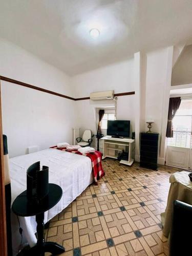 a bedroom with a bed and a table and a television at Penthouse en Buenos Aires in Buenos Aires