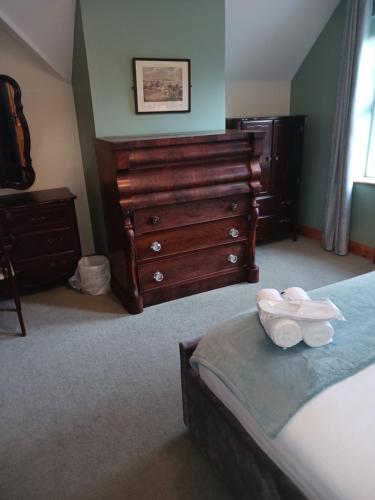 a bedroom with a bed with a dresser and a bed sidx sidx at Tullynacrunat Lodge in Castleblayney