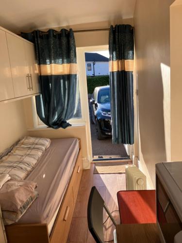 a small bedroom with a bed and a car through the window at Dream private ensuite apartment in Solihull close to Birmingham airport-city centre and NEC in Birmingham