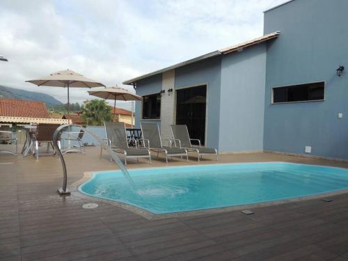 una piscina con una fuente de agua en una casa en Espaço Dunei - Casa inteira com piscina en Catas Altas
