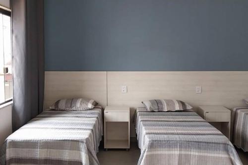 2 Betten in einem Zimmer mit blauen Wänden in der Unterkunft Espaço Dunei - Casa inteira com piscina in Catas Altas