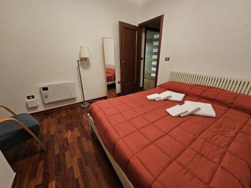 a bedroom with a red bed with towels on it at Appartamento in centro a Rocca di Cambio in Rocca di Cambio