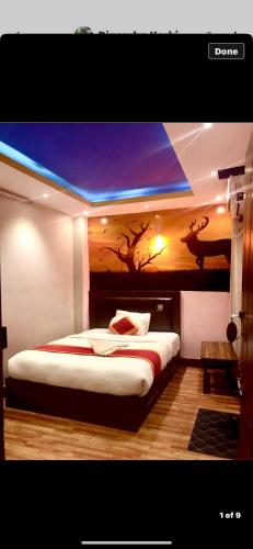 1 dormitorio con 1 cama con una pintura en la pared en Global hotel en Katmandú