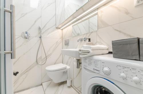 ein Badezimmer mit einer Waschmaschine und einem Waschbecken in der Unterkunft Długi Targ by Loft Apartments in Danzig