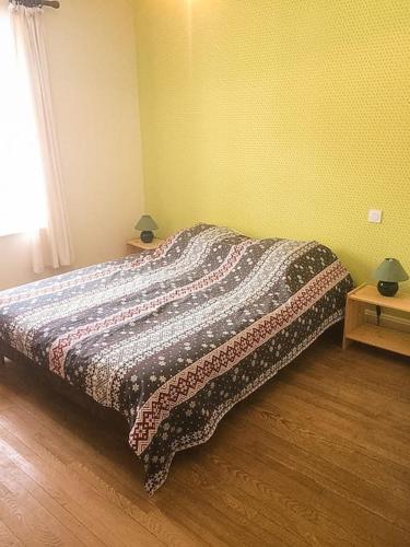 a bedroom with a bed with a blanket on it at Chalet Cosy Lisière de Forêt in Xonrupt-Longemer