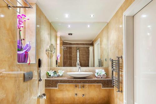 a bathroom with a sink and a mirror at Elinotel Apolamare Hotel in Hanioti
