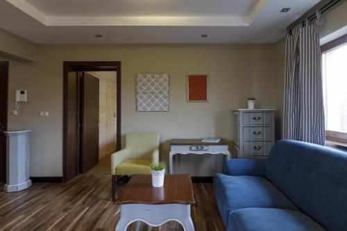 a living room with a blue couch and a table at Villa Rosa in Dunajská Streda