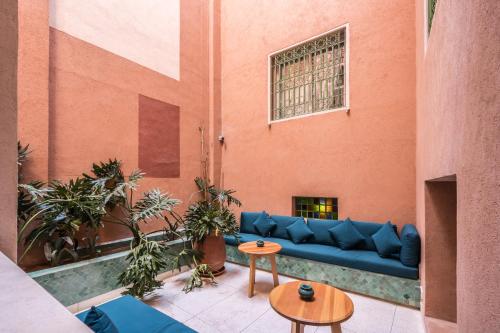 a living room with a blue couch in a building at JEMAA EL FNA Suites & Spa in Marrakech