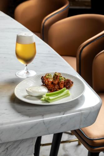 a plate of food and a glass of beer on a table at City of Dreams Mediterranean - Integrated Resort, Casino & Entertainment in Limassol