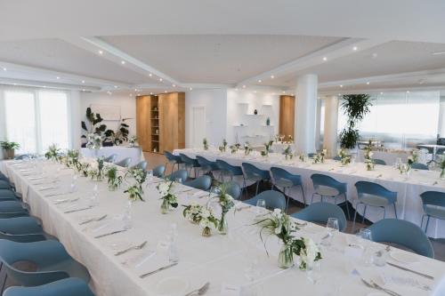 a large room with white tables and blue chairs at Blu Suite Resort in Bellaria-Igea Marina