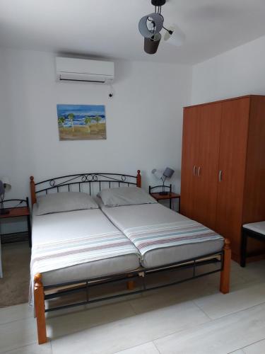 a bedroom with a bed and a wooden cabinet at Ferienhaus Bozena Appartment 3 in Vrsar