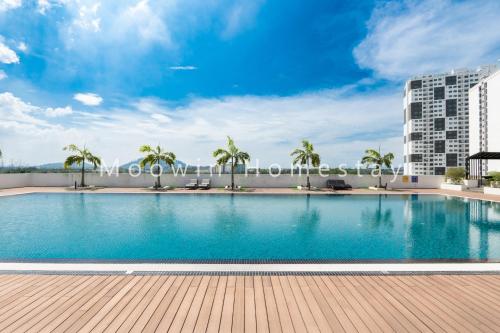 a large swimming pool with palm trees and a building at Cozy&Comfy Suite Room Perai in Perai