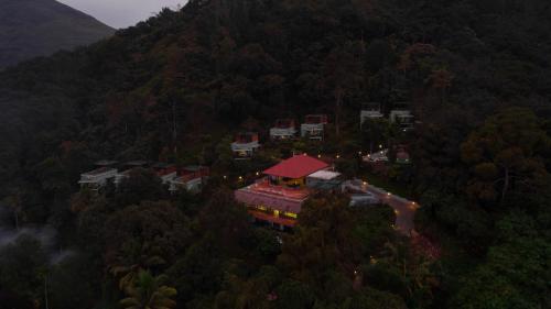 a building in the middle of a mountain with trees at Maram Resort Mamalakandam in Mamalakandam
