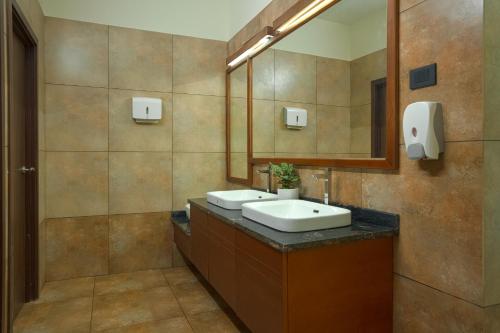 a bathroom with two sinks and a mirror at Maram Resort Mamalakandam in Mamalakandam