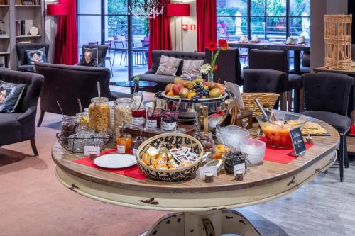 Una mesa con un buffet de comida encima en Garrigae Distillerie de Pezenas - Hotellerie & Spa, en Pézenas