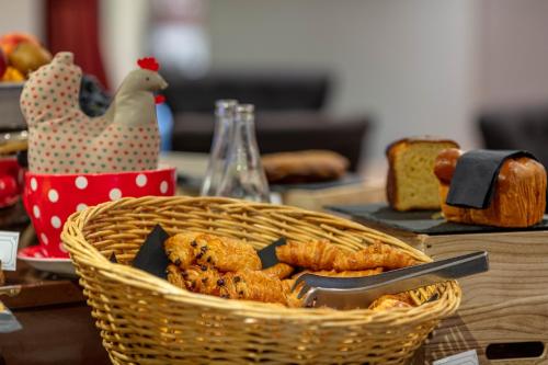 Una cesta de pan y un pollo sobre una mesa. en Garrigae Distillerie de Pezenas - Hotellerie & Spa, en Pézenas
