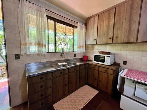 本图贡萨尔维斯Casa da Nona - Vale dos Vinhedos的厨房里有水槽和微波炉