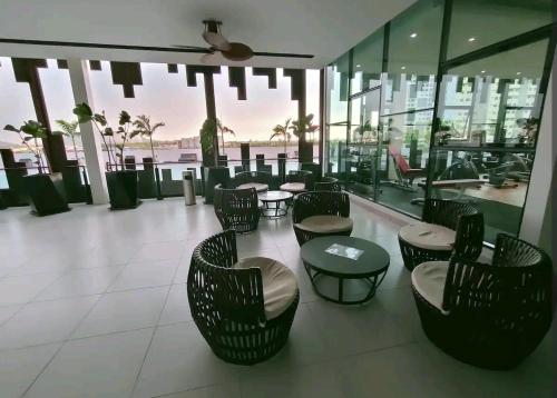 a lobby with chairs and tables in a building at Cozy&Comfy Suite Room Perai in Perai