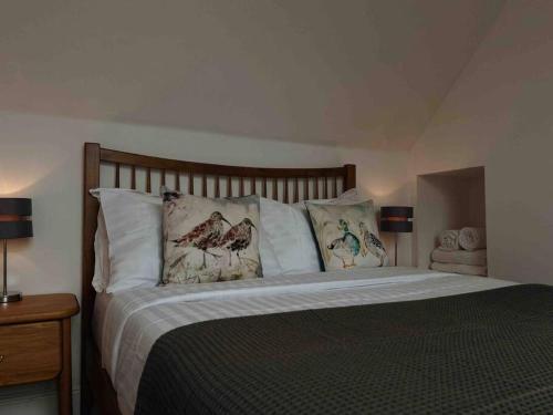 a bedroom with a large bed with pillows at One Bedroom Apartment - Carbost - Skye in Carbost