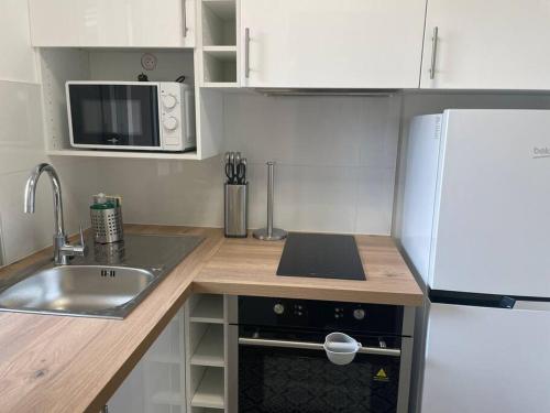 une petite cuisine avec un évier et un réfrigérateur dans l'établissement Le Botanique - À deux pas de Paris - 319B, à Rueil-Malmaison