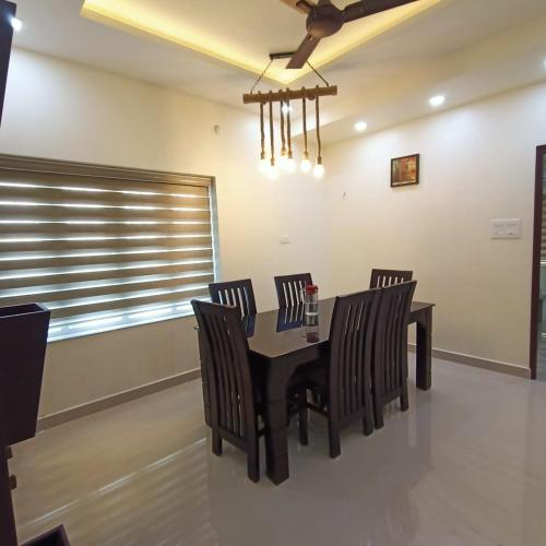 une salle à manger avec une table et des chaises noires dans l'établissement Casa Pearl, à Ernakulam