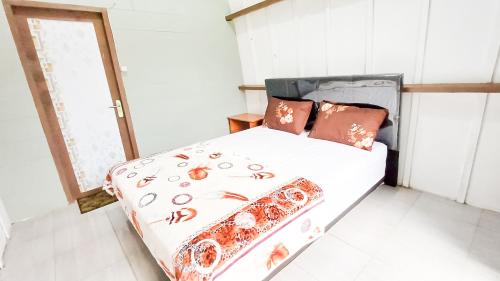 a bedroom with a bed with a bedspread with spiders on it at Tangga Bungalows in Sembalun Lawang