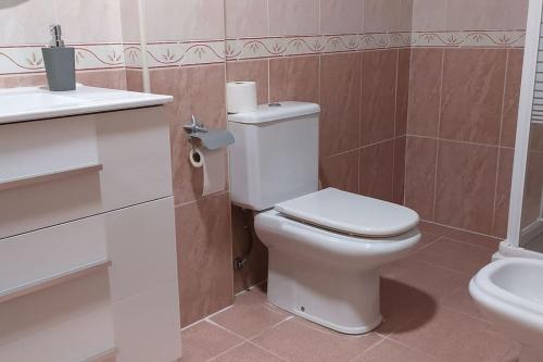 a bathroom with a white toilet and a sink at Acogedor apartamento en la playa de Canet in Canet de Berenguer