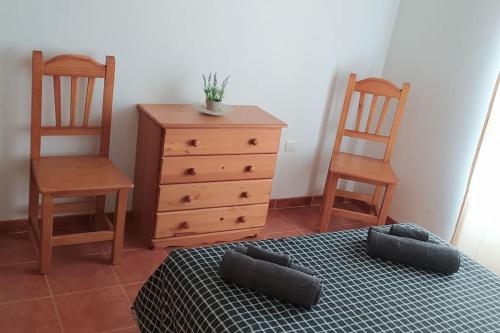 um quarto com 2 cadeiras, uma cama e uma cómoda em Acogedor apartamento en la playa de Canet em Canet d'En Berenguer