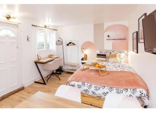 a bedroom with a large bed and a desk at Charmant studio lumineux calme in Asnières-sur-Seine